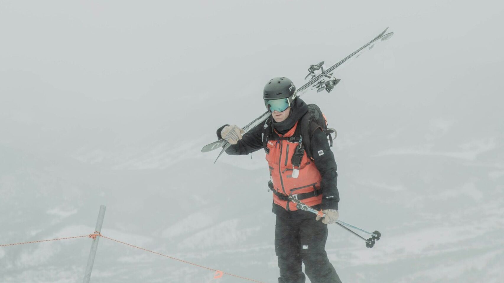 ski patroller with helmet in snowy conditions